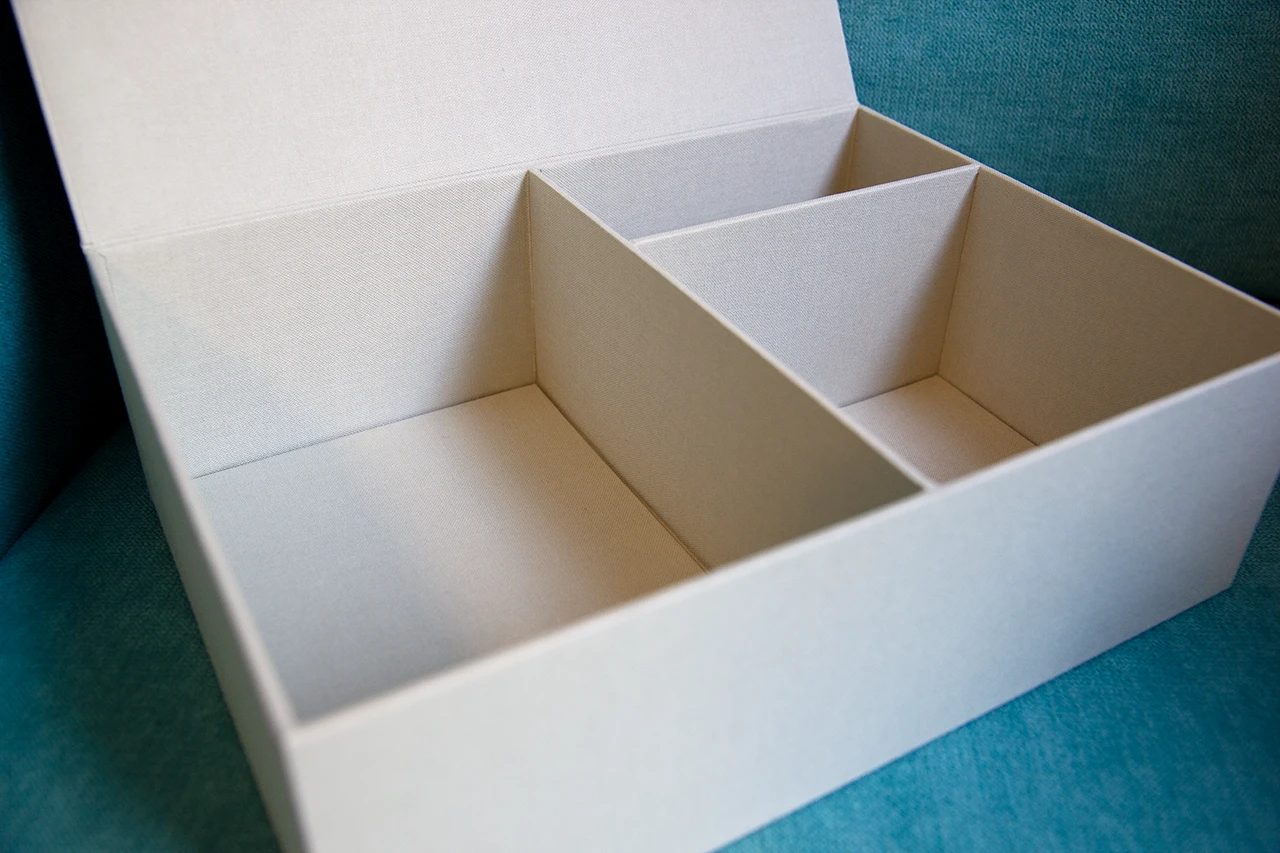 Boîte cartonnée compartimentée recouverte de toile de reliure blanche de chez Winter & Company.