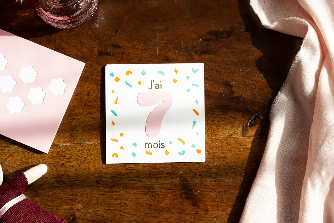 Set de 12 cartes mois anniversaire personnalisables, couleur rose, représentant le 7ème mois, avec des formes géométriques, imprimées artisanalement à la presse Adana et dorées à chaud.