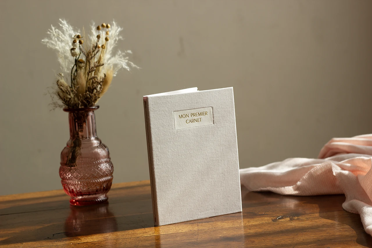 Dorure à chaud traditionnelle sur toile de reliure – carnet de naissance.
