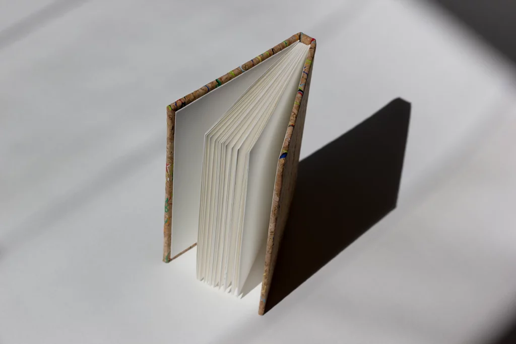 Carnet fait main à l’atelier Forme contre forme, cousu à la main, avec une couverture en toile de liège Wonderland de chez HZCORK — vue de face, ouvert. Carnet fait main à l’atelier Forme contre forme, cousu à la main, avec une couverture en toile de liège Wonderland de chez HZCORK — vue de face, ouvert.