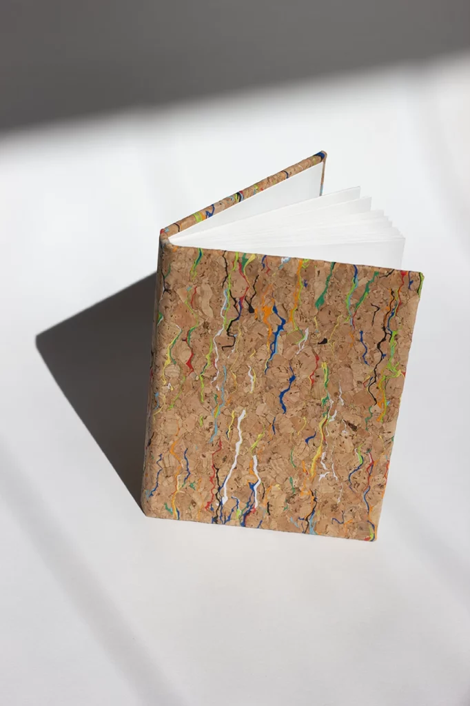 Carnet fait main à l’atelier Forme contre forme, cousu à la main, avec une couverture en toile de liège Wonderland de chez HZCORK — vue de profil.