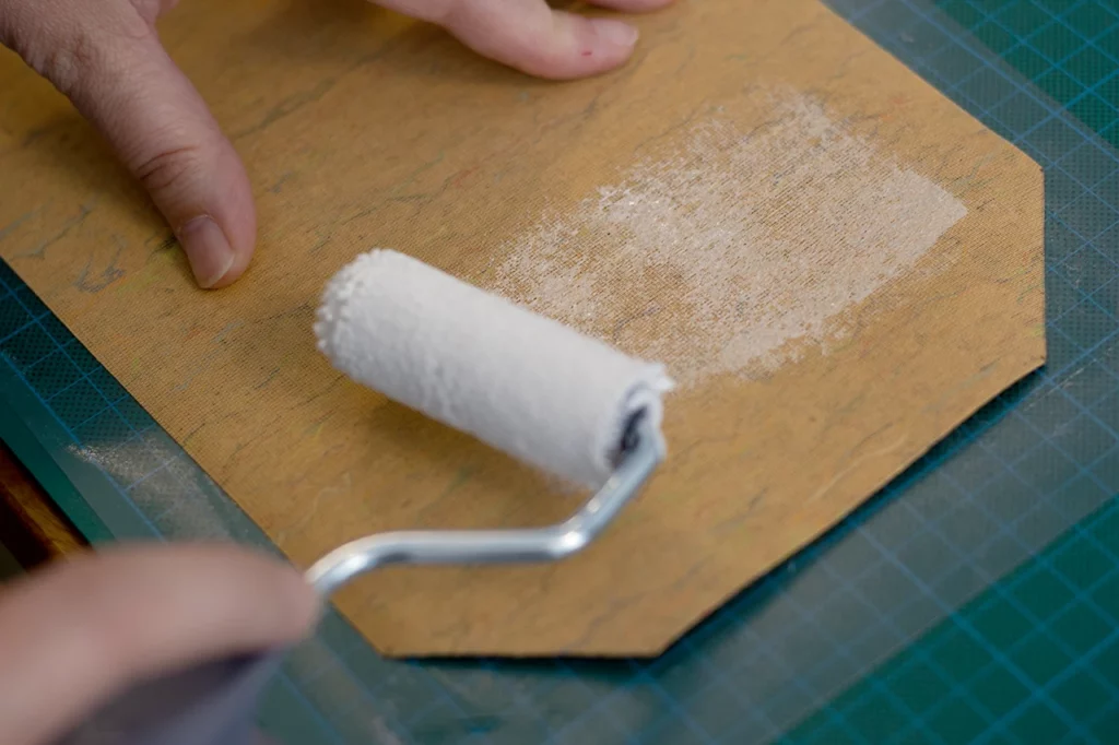 Encollage de la toile de liège pour la fabrication d’une couverture de carnet fait main. Encollage de la toile de liège pour la fabrication d’une couverture de carnet fait main.