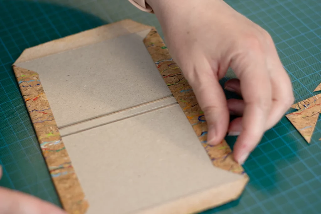 Rembordage de la couverture réalisée en toile de liège. Rembordage de la couverture réalisée en toile de liège.