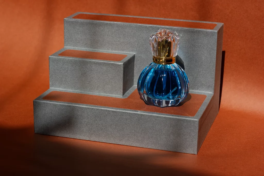 Présentoir à parfum en papier Favini Tokyo avec un flacon bleu.