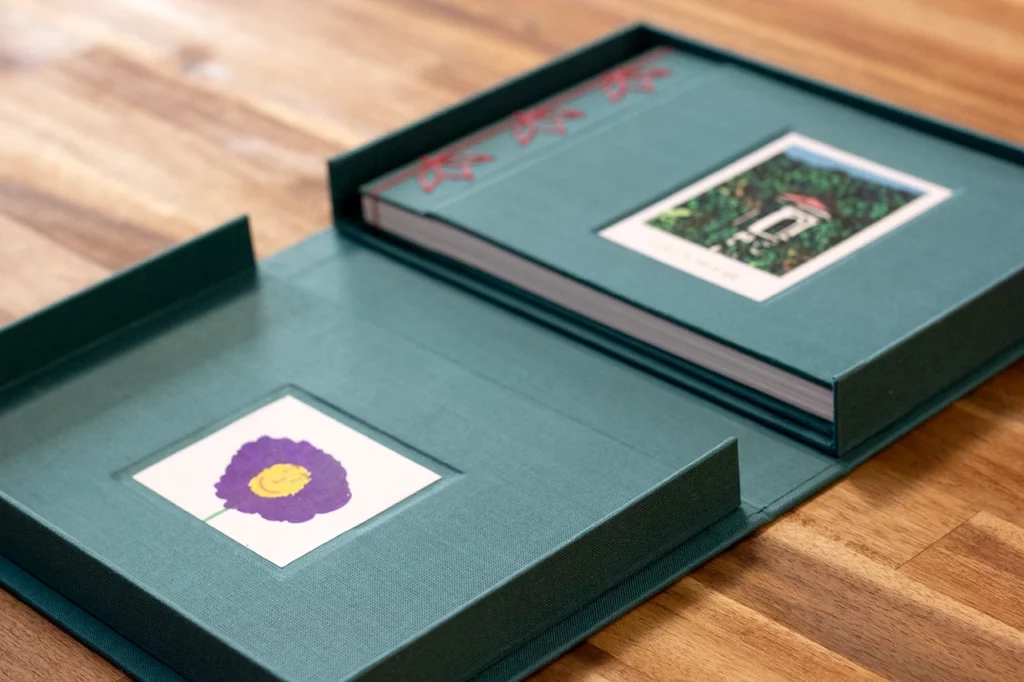 Boîte à clapet ouverte, révélant d’un côté l’illustration réalisée par Laura enfant, et de l’autre le carnet fabriqué à l’atelier.