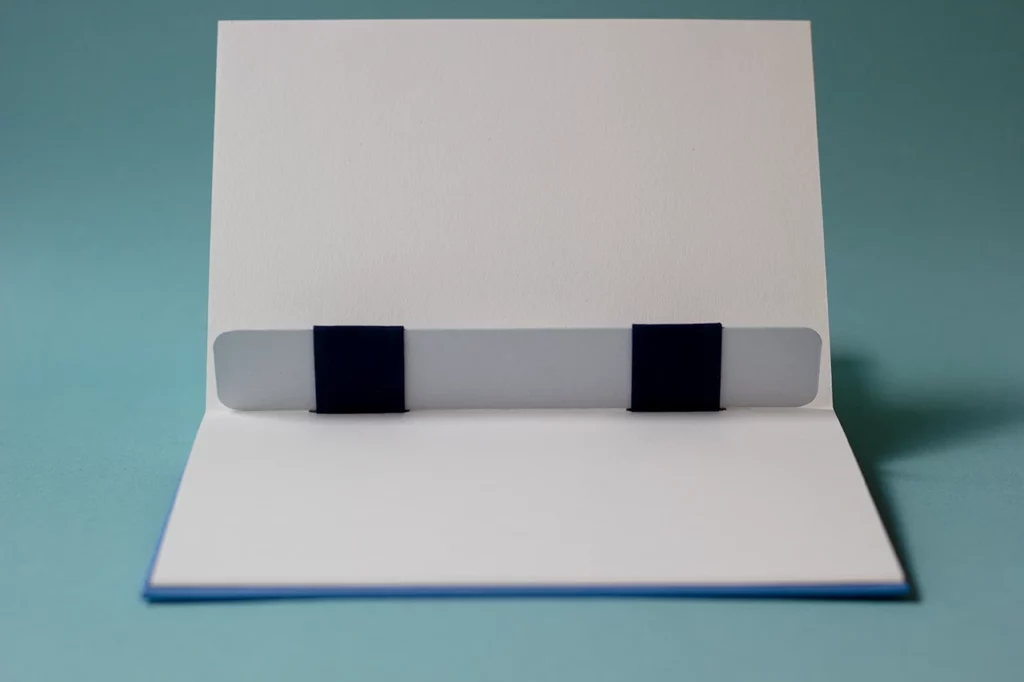 Carnet avec une reliure australienne ouvert, laissant apparaître le gond plat pouvant servir de marque-page.