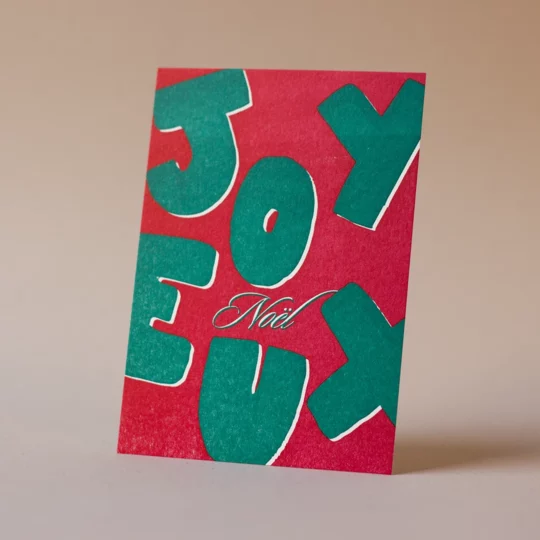 Carte de vœux simple « Joyeux Noël » verte et rouge en letterpress imprimée et façonnée dans mon atelier Forme contre forme.