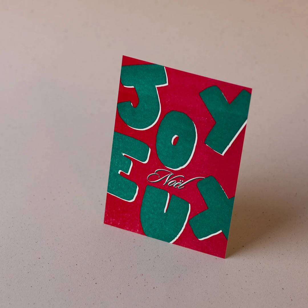 Carte de vœux simple « Joyeux Noël » verte et rouge en letterpress imprimée et façonnée dans mon atelier Forme contre forme.