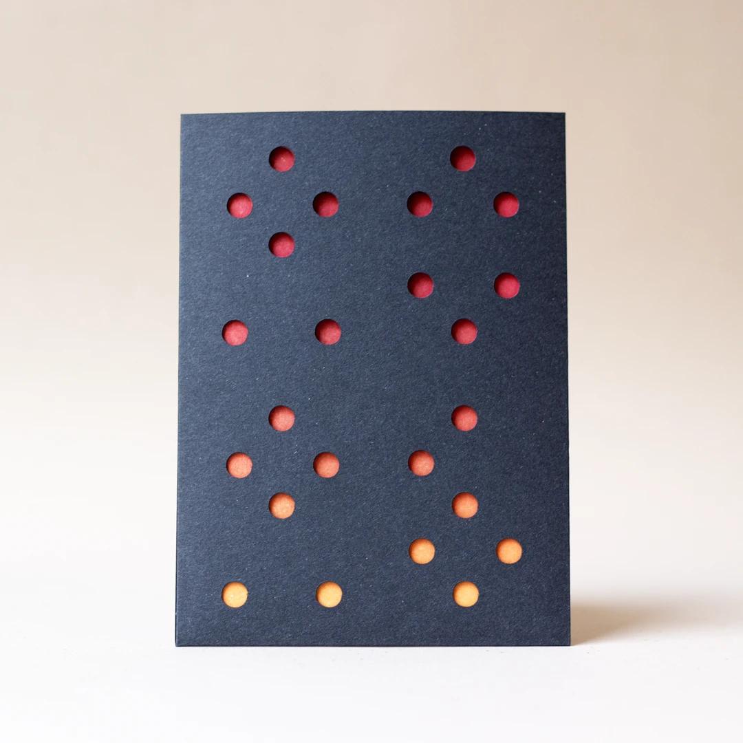 Carte de vœux simple « Planètes 2026 » avec un effet de gradient rouge / jaune soleil en letterpress, avec un fourreau noir, imprimée et façonnée dans mon atelier Forme contre forme.