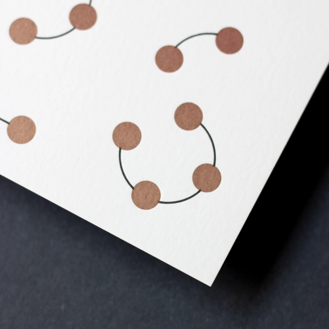 Carte de vœux simple « Planètes 2026 » dorée et noire en letterpress, avec un fourreau noir, imprimée et façonnée dans mon atelier Forme contre forme.