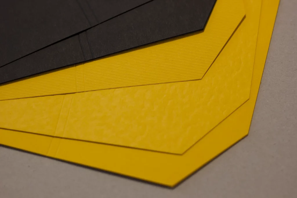 Zoom sur les couvertures à formes géométriques jaunes et noires pour les carnets en reliure Singer.