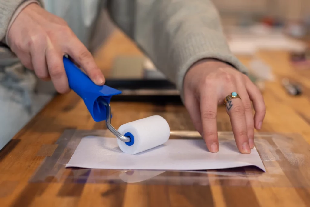 Encollage de la toile de reliure pour la réalisation d’une couverture de carnet lors d’un atelier chez Forme contre forme à Bordeaux.