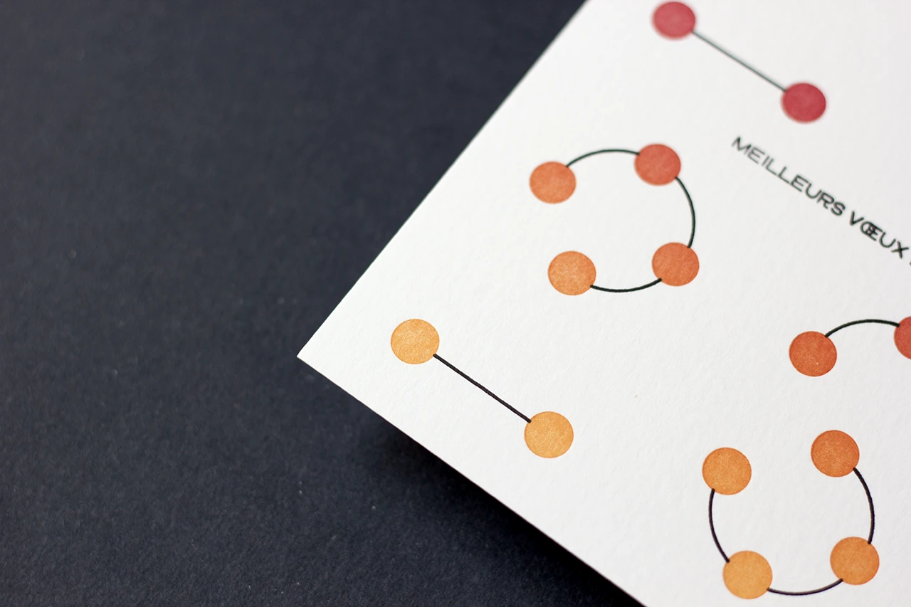 Zoom sur le bas de la carte « Planètes 2026 », imprimée en letterpress avec un effet de dégradé rouge et jaune soleil sur les planètes.