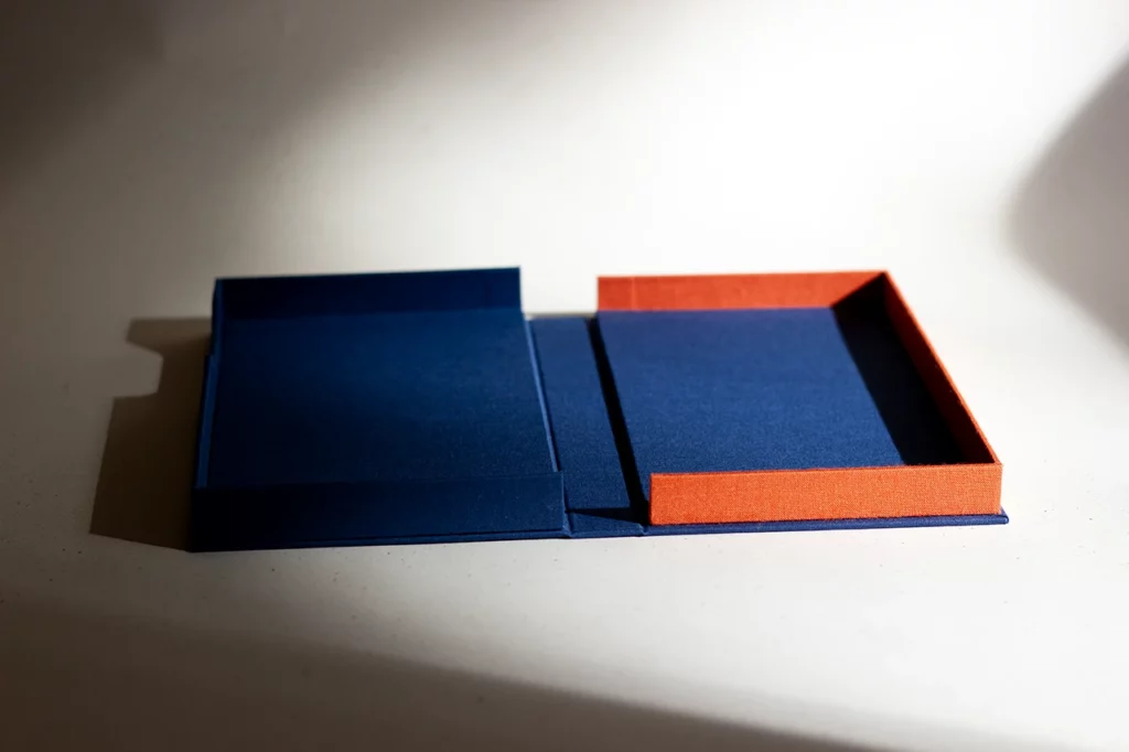Coffret solander ouvert sur mesure en toile du Marais bleu marine et orange — Atelier Forme contre forme, Bordeaux — rayon de soleil, vue d’ensemble.