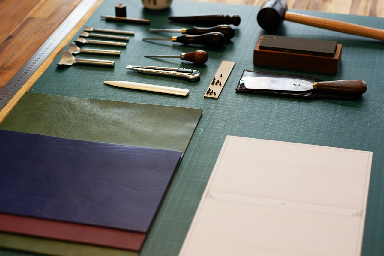 Matériel indispensable pour la fabrication d’un carnet en cuir (couteau à parer, lissette brunissoir, abat-carre, emporte-pièce, alêne) — Atelier Forme contre forme, Bordeaux.