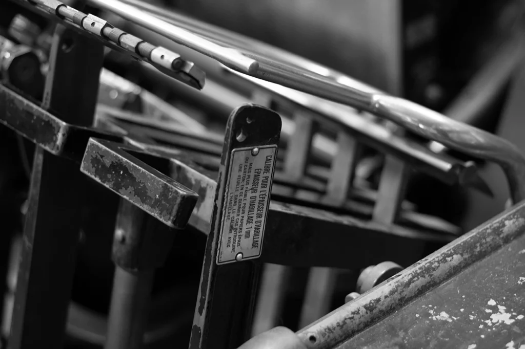 Zoom sur le souffleur de réception et l’équerre de réception avec guide — platine Heidelberg OFMI, Atelier Forme contre forme, Bordeaux (noir et blanc).