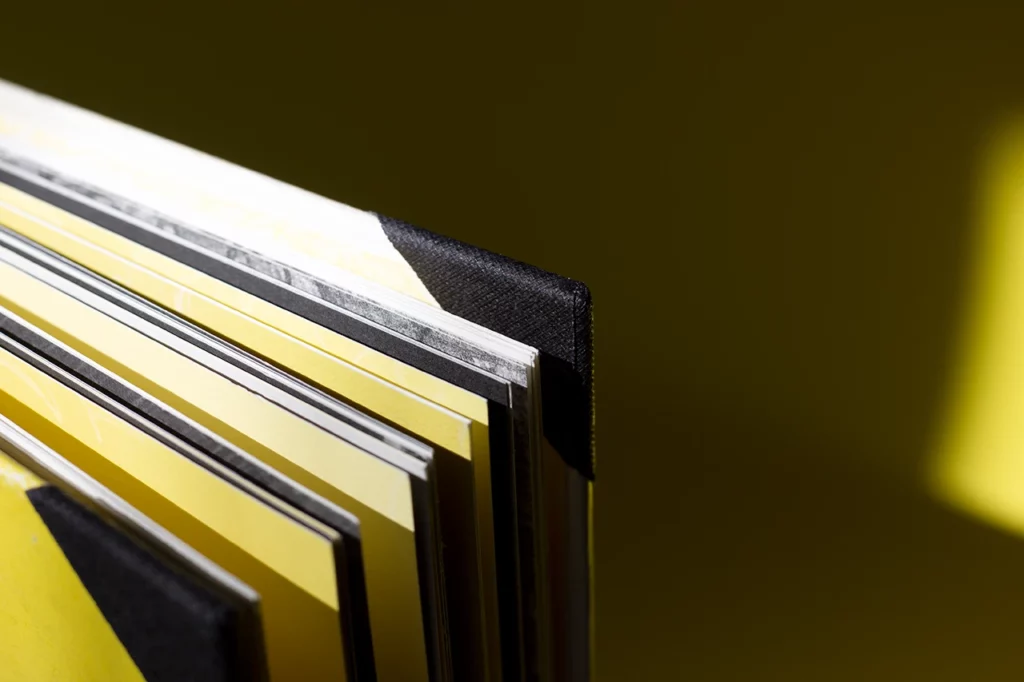 Zoom sur les coins renforcés en toile de reliure noire pour réparer un livre abîmé — Atelier Forme contre forme, Bordeaux.