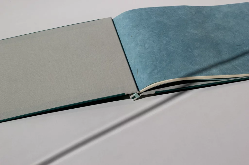 Livre d’or en reliure japonaise avec contreplats gris et pages de garde en papier népalais vert Véronèse — Atelier Forme contre forme, Bordeaux.