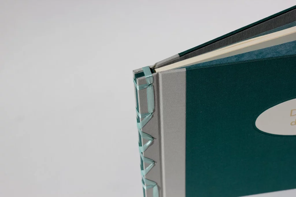 Vue de dessus d’un livre d’or de mariage en reliure japonaise, couverture en toiles vert foncé et grise, avec mors gris — Atelier Forme contre forme, Bordeaux.