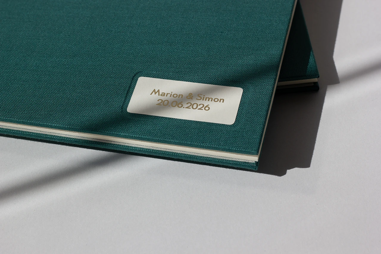 Zoom sur la cuvette en cartonnage du livre d’or avec cartel, prénom des mariés et dorure à chaud — Atelier Forme contre forme, Bordeaux.