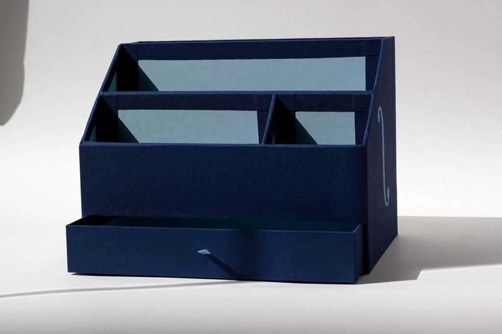 Organiseur de bureau sur mesure en toile du Marais bleu marine, marqueterie de toile inspirée d’un violoncelle, intérieur Fedrigoni Celeste — Atelier Forme contre forme, Bordeaux.