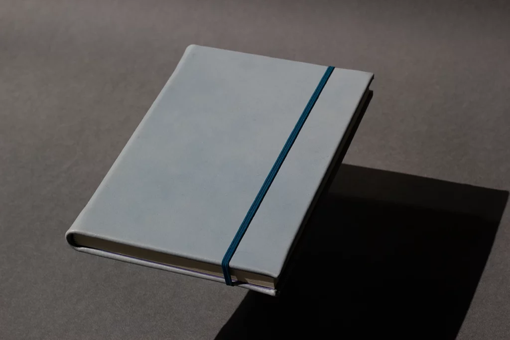 Carnet en cuir bleu réalisé lors d’ateliers sur mesure, avec couverture rigide en cuir sellier végétal — Atelier Forme contre forme, Bordeaux.